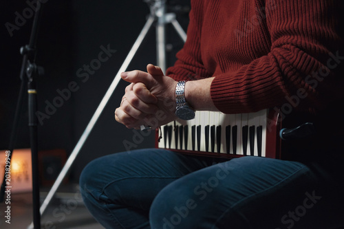 Melodica in hands of man, wind instrument, recording of music in the studio