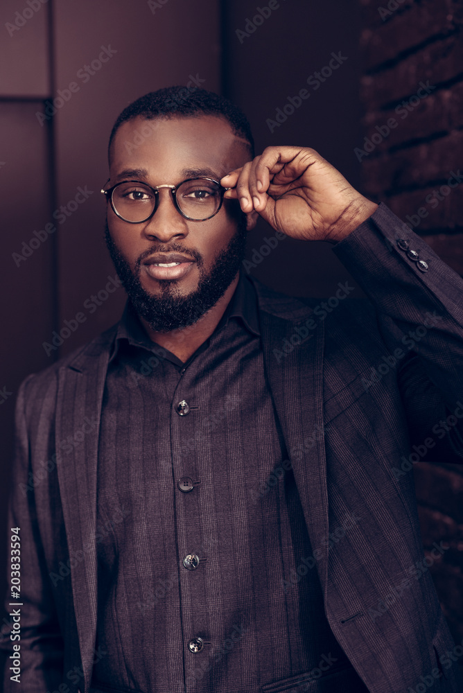 Handsome intelligent man fixing his glasses Handsome intelligent man fixing his glasses