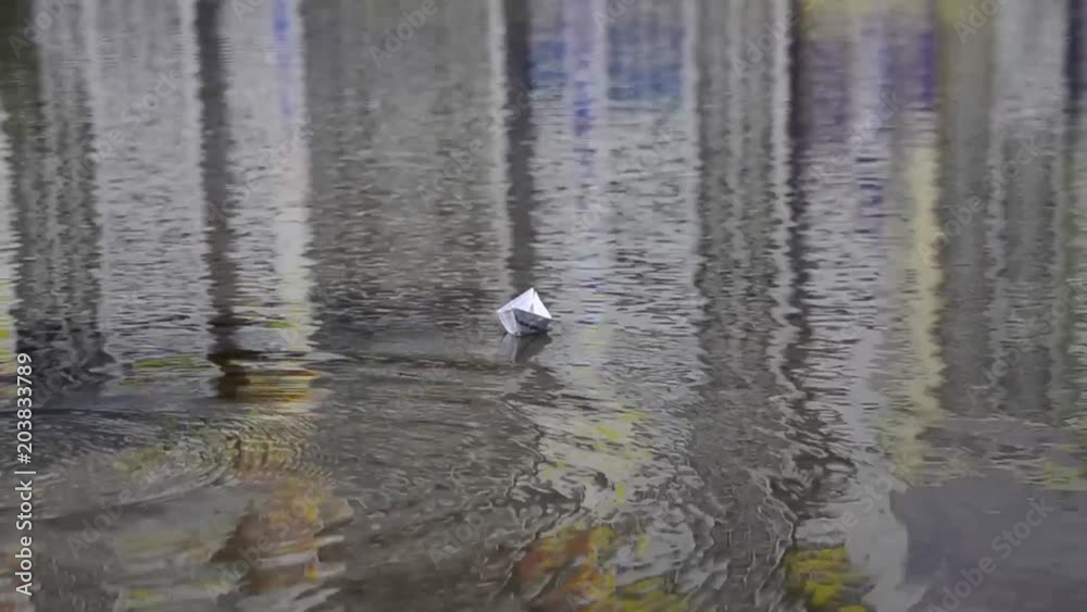 Girl start up paper boat in a puddle Girl start up paper boat in a puddle