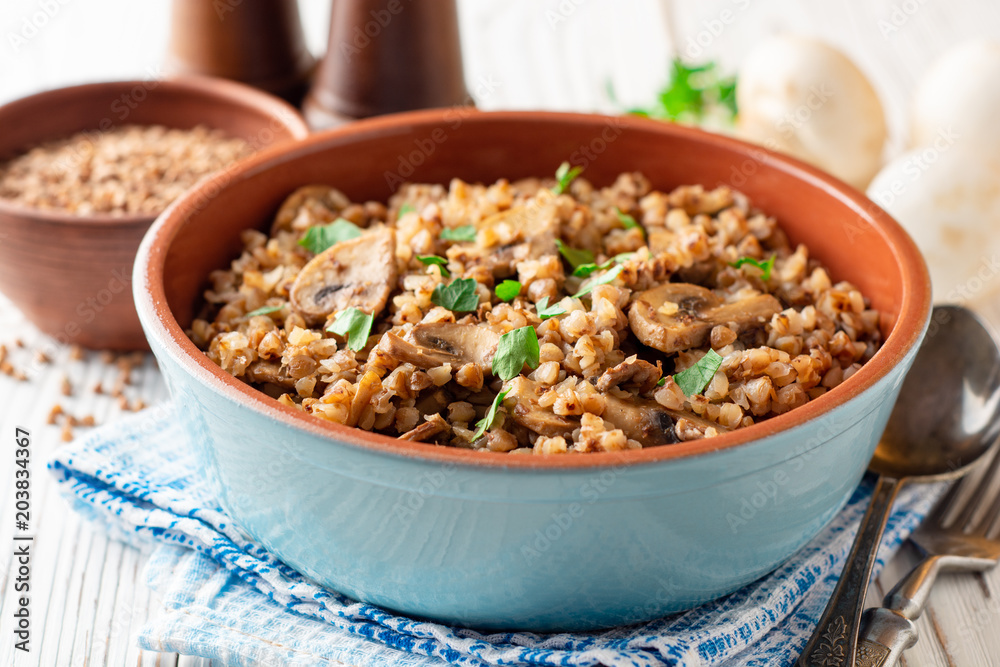 Buckwheat porridge with mushrooms in a bowl on white wooden background Buckwheat porridge with mushrooms in a bowl on white wooden background