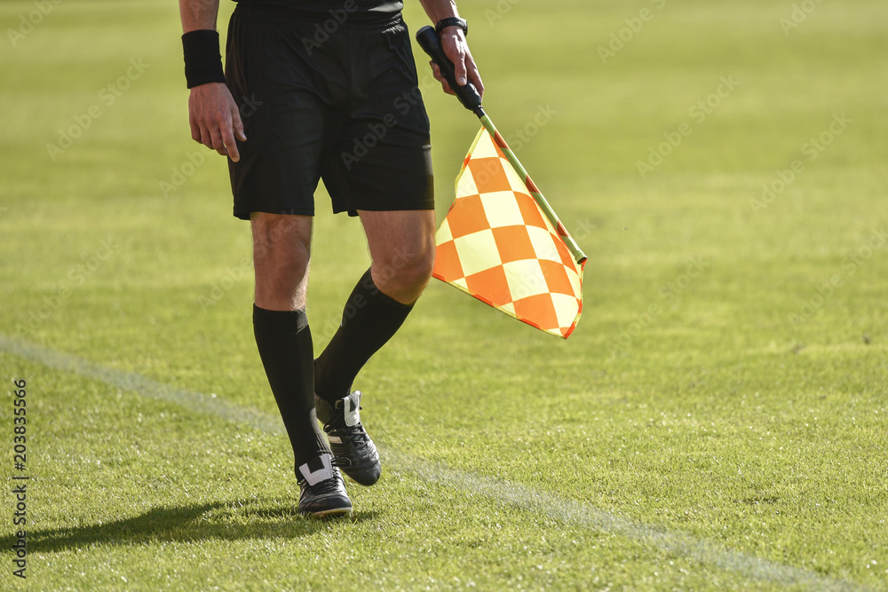 Legs and flag of assistant football referee Legs and flag of assistant football referee