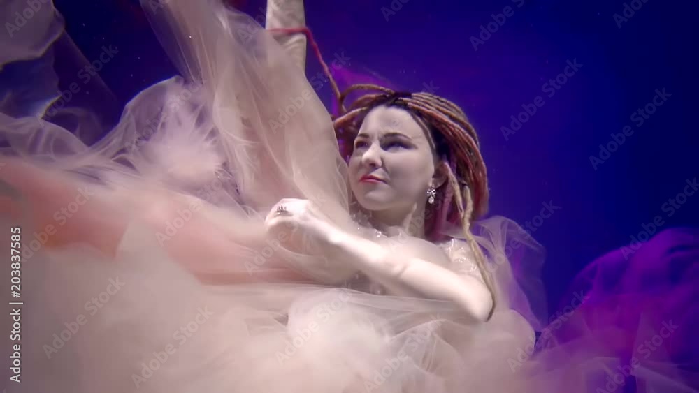 a mystical woman is on the seabed and elegantly moves her hands, her hair is braided in dreadlocks a mystical woman is on the seabed and elegantly moves her hands, her hair is braided in dreadlocks