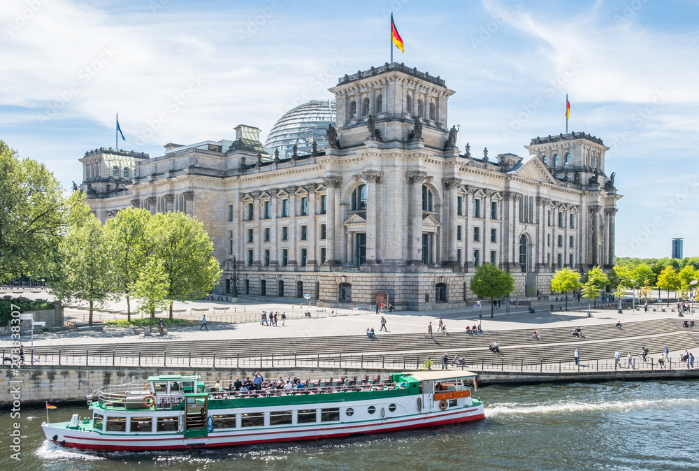 Tourist boat at German Reichtag building at government district in Berlin