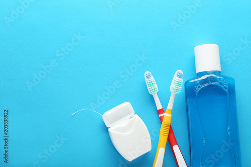Toothbrush with mouthwash bottle on blue background