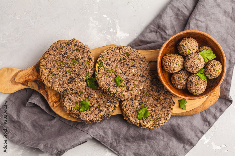 Vegan beans burgers (cutlets) and meatballs with parsley on a wooden board, top view copy space. Healthy vegan food concept. Vegan beans burgers (cutlets) and meatballs with parsley on a wooden board, top view copy space. Healthy vegan food concept.
