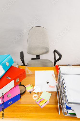 Wooden desk full of colorful ring binders photo