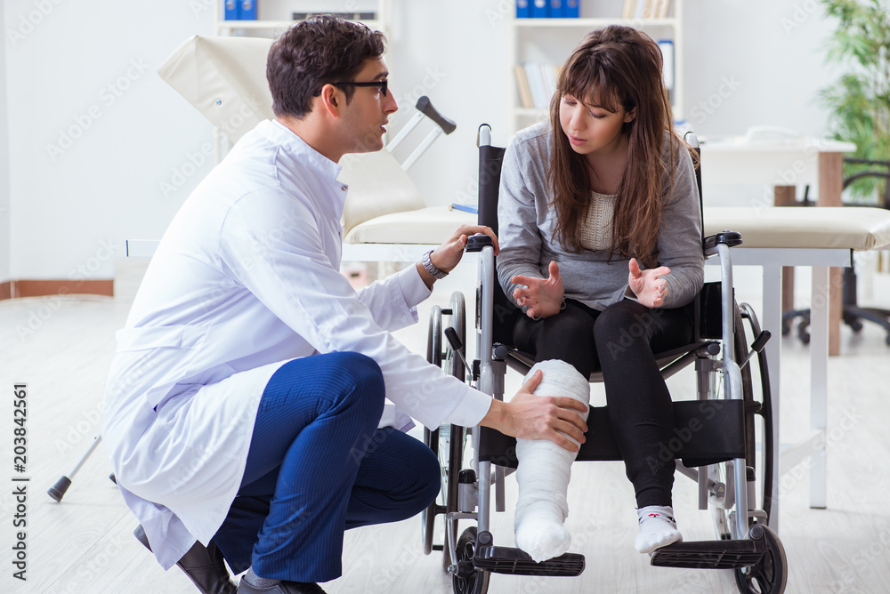 Male doctor examining female patient on wheelchair Male doctor examining female patient on wheelchair