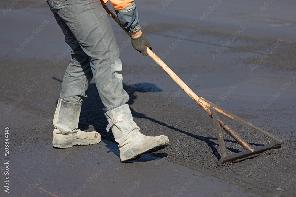 Construction road worker levelling hot mix flexible asphalt concrete  pavement Photos | Adobe Stock