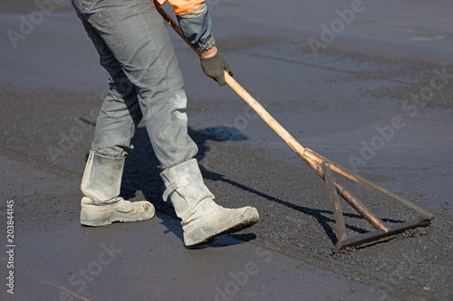 Photography Construction road worker levelling hot mix flexible asphalt concrete pavement