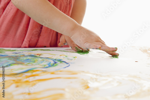 Сute little girl learns to paint as the most powerful investment in successful future. Creativity, education, success concept.