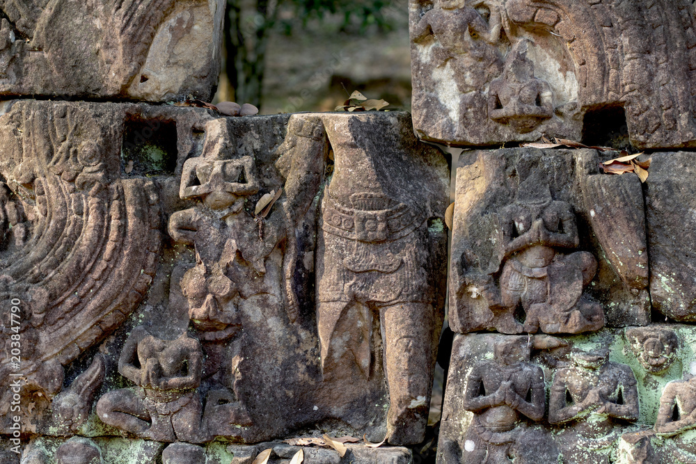 Carved figures bas-relief of Angkor Wat complex temple, Siem Reap, Cambodia. Stone ruin puzzle with buddha