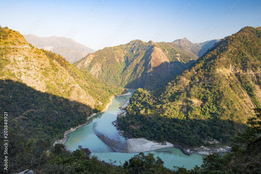 Wonderful green peaks of some mountains with the Ganges river flowing between them in Rishikesh, India