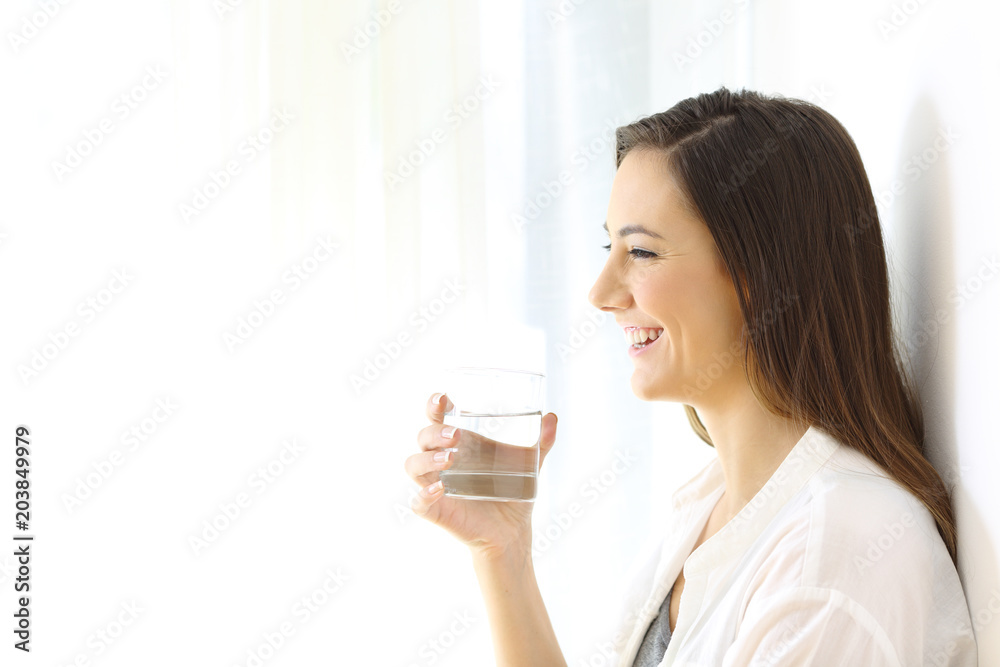 Profile of a happy woman holding a glass of water Profile of a happy woman holding a glass of water