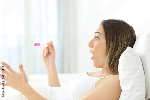 Amazed woman checking a pregnancy test