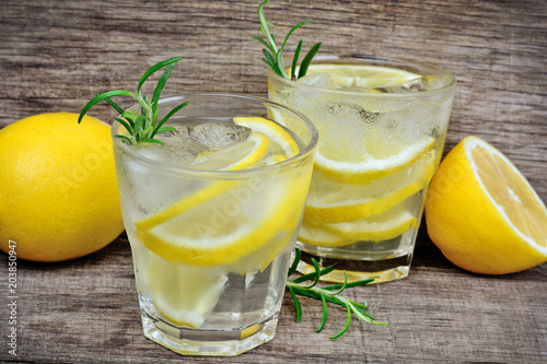 Lemon with rosemary infused detox water on wooden table