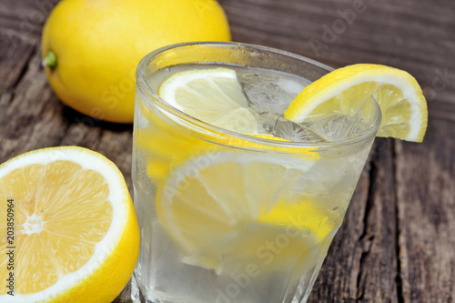 Glass of fresh water with a lemon on table