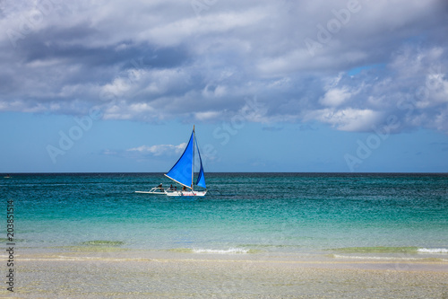 One double outrigger sailboat on the sea