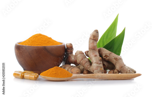 Turmeric , turmeric powder in wooden cup with wooden spoon and turmeric capsules