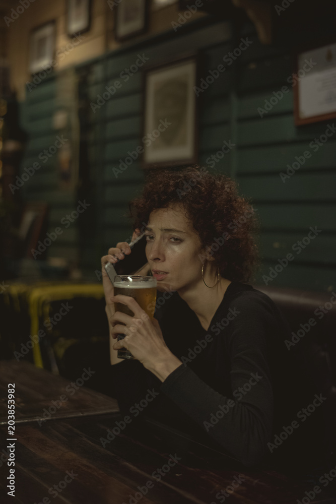 Woman having a beer at a bar