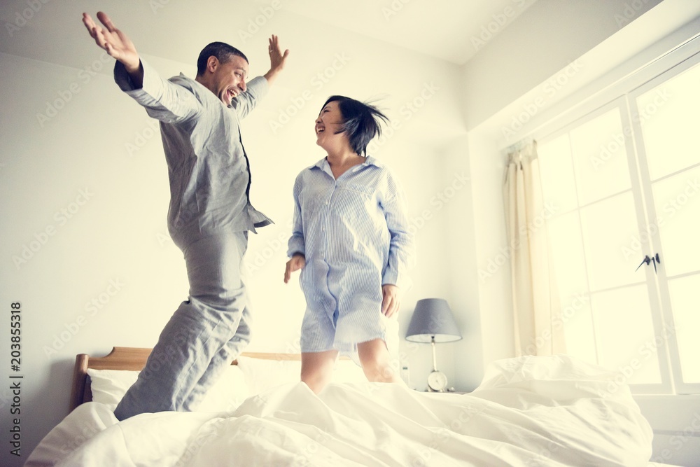 A couple jumping on the bed A couple jumping on the bed