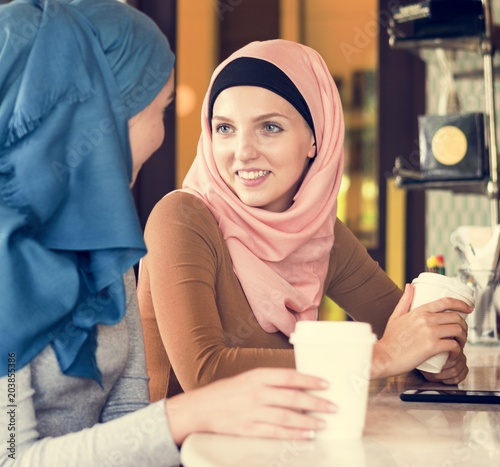 Canvas Print Islamic women friends enjoying and talking in the coffee shop
