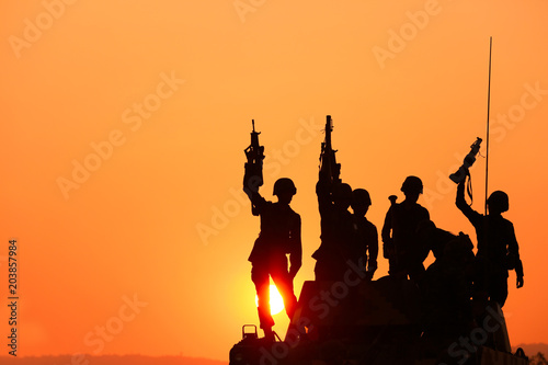 Soldiers silhouettes against a sunset. The winner concept.