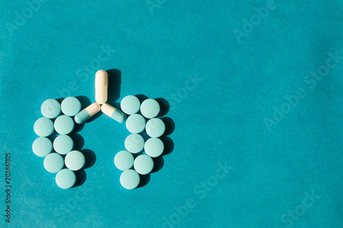 on a blue background from tablets the form of human lungs is laid out. The concept of a cure for lung