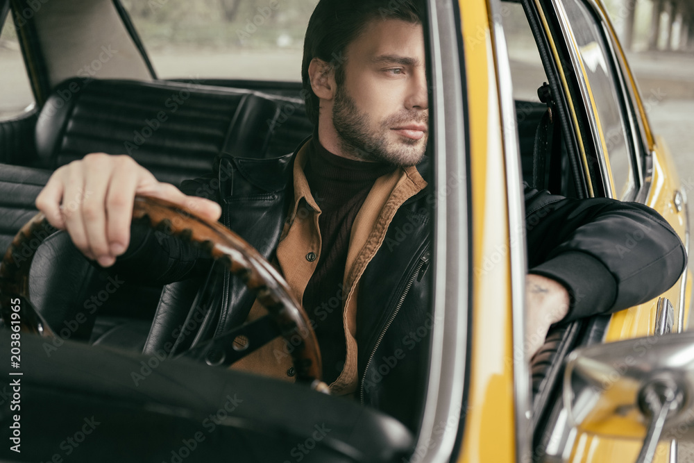 pensive handsome stylish man sitting in retro car and looking away pensive handsome stylish man sitting in retro car and looking away