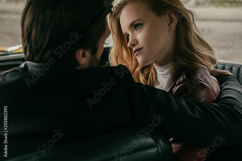 back view of sensual young couple in love sitting together in car