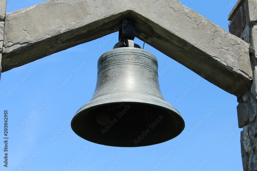 a close view of a church bell, with a portion of the supporting structure