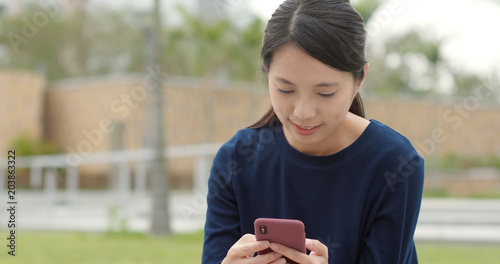 Asian student work on smart phone in park