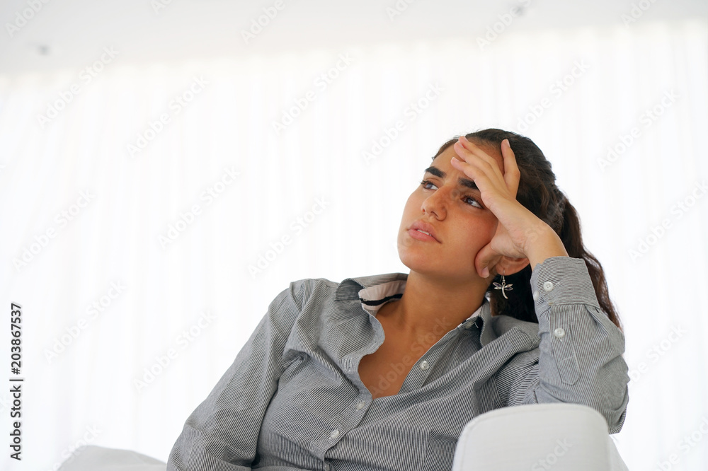 Woman suffering from headache migraine pain at home. Health problem, stress and depression. Female holds head with hand. Concept of health. Woman suffering from headache migraine pain at home. Health problem, stress and depression. Female holds head with hand. Concept of health.