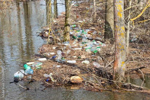 Spring flood of river, plastic trash piled up to trees