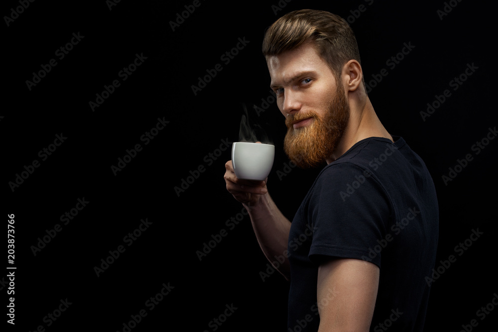 Cheerful professional handsome project manager in black t-shirt holding coffee cup drinking morning espresso coffee standing on black background Bearded man is tasting coffee Cheerful professional handsome project manager in black t-shirt holding coffee cup drinking morning espresso coffee standing on black background Bearded man is tasting coffee