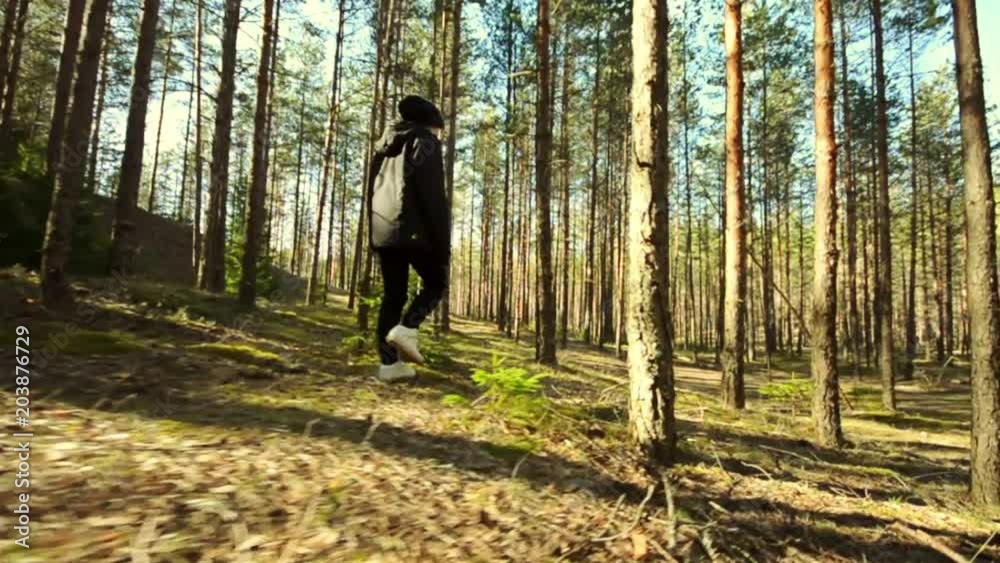 Young Female Walking among trees in forest. Slow motion footage. Amazing sunset, summer landscape. Young Female Walking among trees in forest. Slow motion footage. Amazing sunset, summer landscape.