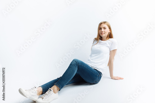 Young girl posing and smiling, on a white background slender blonde