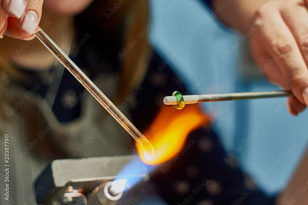 Artist of glass at work. Hand made glass beads in the fire out of red hot glowing glass for pandora bracelets Artist of glass at work. Hand made glass beads in the fire out of red hot glowing glass for pandora bracelets