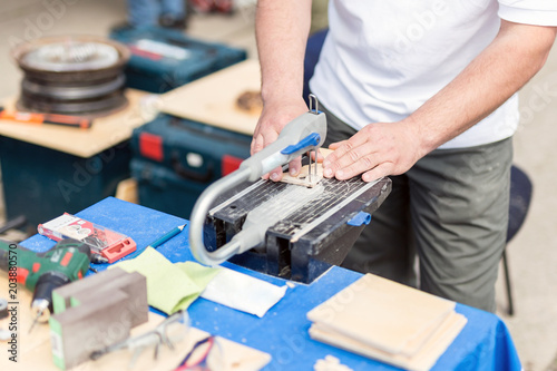 Man working with jig saw. Fretsaw tool stationary fixed on table. Person making wooden figures with electric saw tool