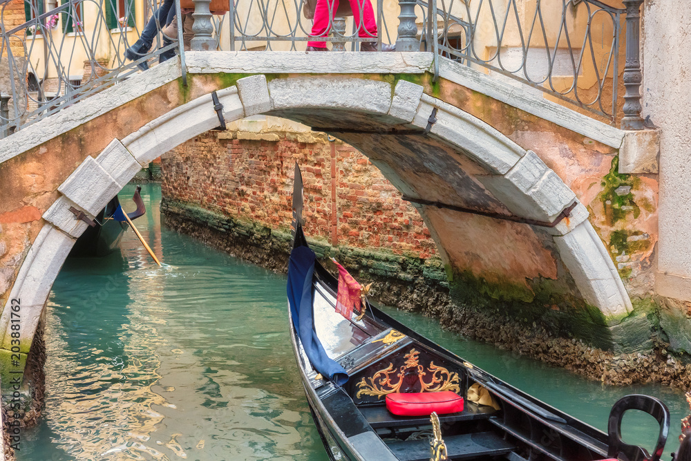 Bridge cross Venetian canal with gondola in Venice, Italy. 