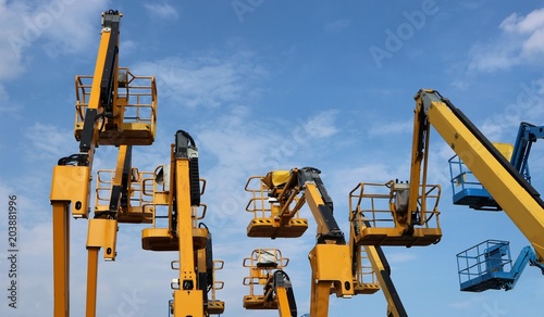 Wallpaper Mural Aerial work  platform of cherry pickers on blue cloudy sky  background Torontodigital.ca