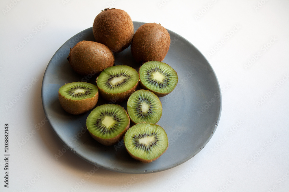 Juicy kiwi fruits isolated on grey concrete plate Juicy kiwi fruits isolated on grey concrete plate