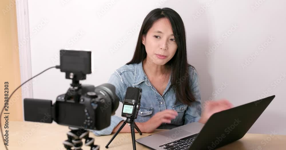 Woman taking video and present with notebook computer at home Woman taking video and present with notebook computer at home