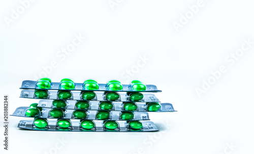 Stacks of green round sugar-coated tablet pills in blister packs on white background with copy space. Pharmaceutical marketing. Pharmaceutical industry. Dextromethorphan : medicine for dry cough