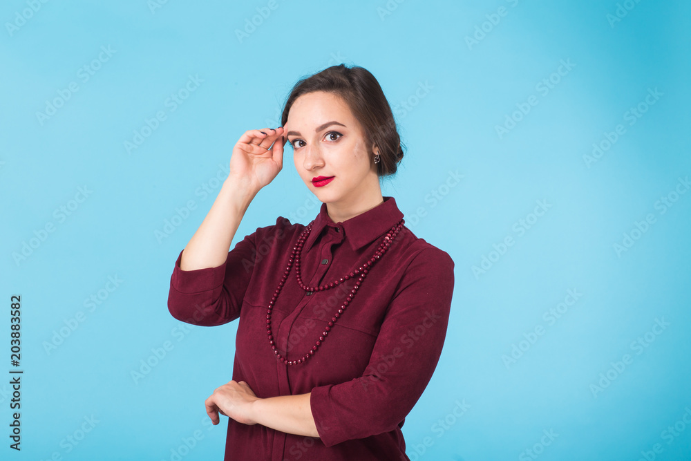 Confident young woman standing over blue background Confident young woman standing over blue background