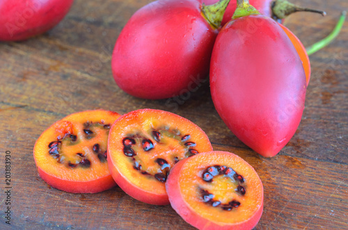 Red tamarillo  or  tree tomato cut into slices on cut board. Exotic fruit Tamarillo background. photo