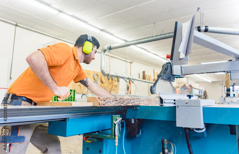 Carpenter cutting board with table saw in his workshop Carpenter cutting board with table saw in his workshop
