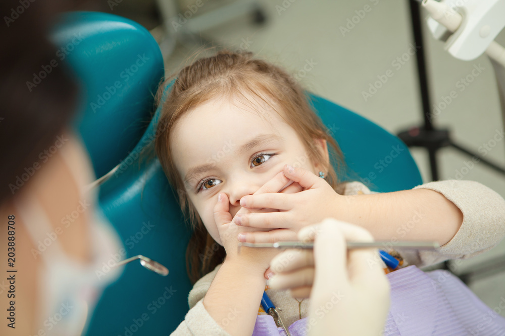 Kid afraid of procedure closes mouth with hands Kid afraid of procedure closes mouth with hands