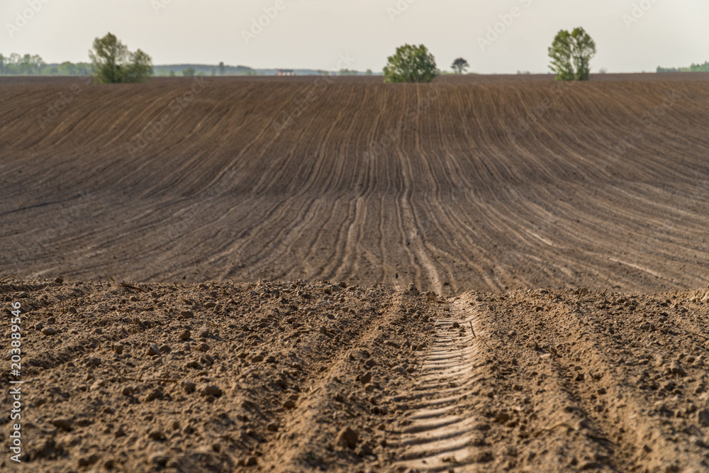 View oа a ploughed fields with a tractor tire track. View oа a ploughed fields with a tractor tire track.