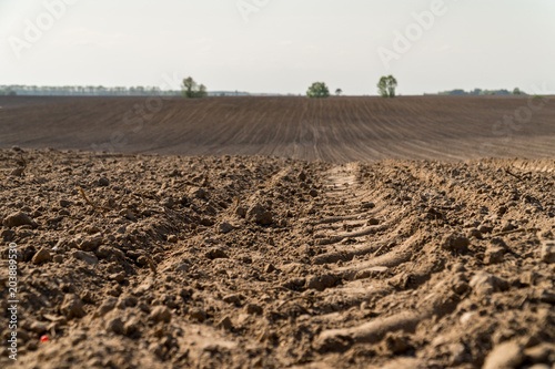 Fotografia View oа a ploughed fields with a tractor tire track.