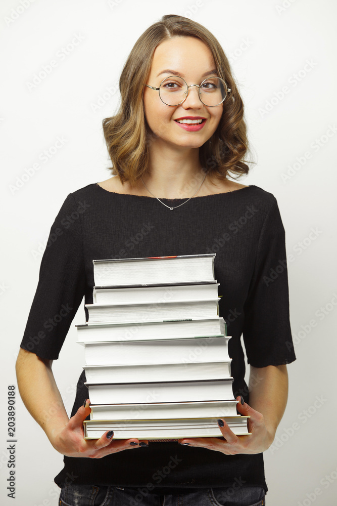 Portrait of attractive woman with stack of books in hands, has happy expression, passed the exams at the end of school or university, stands over white isolated background. Portrait of attractive woman with stack of books in hands, has happy expression, passed the exams at the end of school or university, stands over white isolated background.